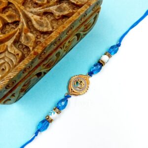 ARNAS 1 PC GOLDEN OM CHARMS WITH BLUE & WHITE PEARL DESIGNER RAKHI